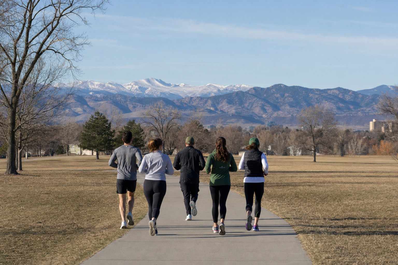 A group of runners on a flat path in a Denver park
